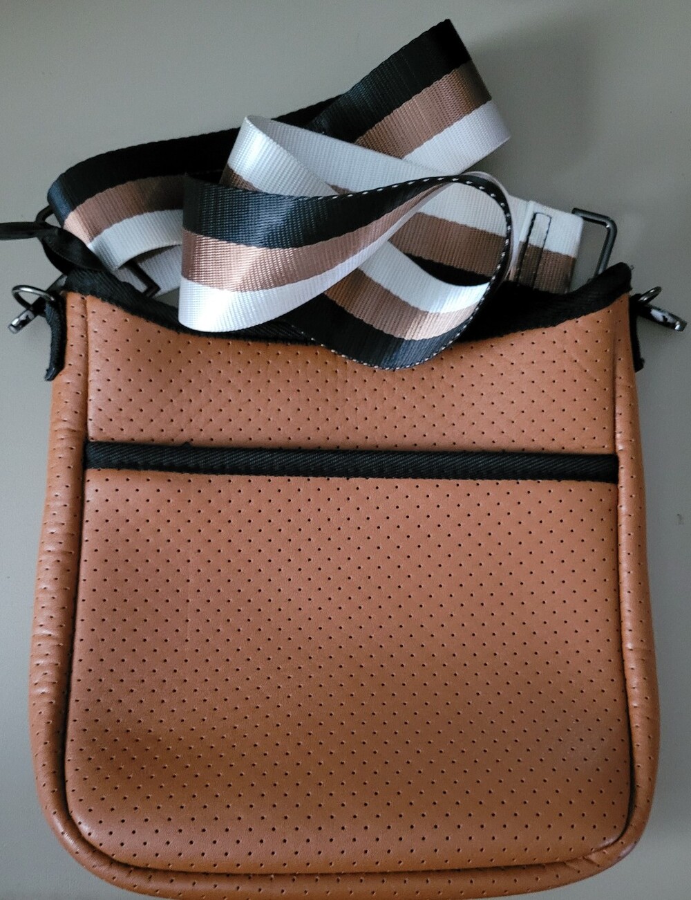 Haute Shore Perforated Tan Crossbody Bag with Striped Adjustable Strap.